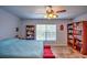 Spacious bedroom with a ceiling fan, tile flooring, and built-in bookcases at 10064 Cocoa Beach St, Port Charlotte, FL 33981