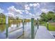 Pier extending into a canal with green wooden pilings and a gray wood walkway at 10064 Cocoa Beach St, Port Charlotte, FL 33981