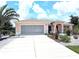 Inviting single-story home featuring a neutral color palette, a well-maintained driveway, and manicured landscaping at 10064 Cocoa Beach St, Port Charlotte, FL 33981