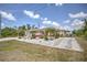 Single-Gathering home featuring a two-car garage, well-maintained landscaping, driveway, and an American flag at 10064 Cocoa Beach St, Port Charlotte, FL 33981