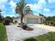 Charming single-story home featuring a well-manicured yard with a decorative rock garden and mature landscaping at 10064 Cocoa Beach St, Port Charlotte, FL 33981