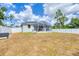 Backyard featuring a screened-in lanai and white vinyl privacy fence at 129 David Blvd, Rotonda West, FL 33947
