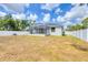 View of backyard and screened in patio, surrounded by a white fence at 129 David Blvd, Rotonda West, FL 33947