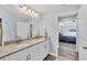 Bathroom with a double vanity and view into a bedroom with tray ceiling at 129 David Blvd, Rotonda West, FL 33947