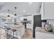 Bright kitchen with stainless steel appliances, granite countertops, and an island with barstool seating open to the dining area at 129 David Blvd, Rotonda West, FL 33947