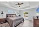 Comfortable main bedroom with tray ceiling, wood-look floors, and ample natural light from multiple windows at 129 David Blvd, Rotonda West, FL 33947