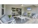 Relaxing screened-in patio featuring comfortable seating and a mounted television at 129 David Blvd, Rotonda West, FL 33947