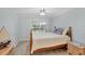 Comfortable bedroom with ceiling fan features neutral walls, wood-trimmed furniture, and a large window at 149 Englewood Isles Pkwy # 603, Englewood, FL 34223
