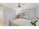 Comfortable bedroom features a plush bed, ceiling fan, large window, and wooden furniture at 149 Englewood Isles Pkwy # 603, Englewood, FL 34223