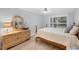 Cozy bedroom with ample natural light features a dresser with decorative mirror and nautical decor at 149 Englewood Isles Pkwy # 603, Englewood, FL 34223