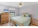 Relaxing bedroom with a wooden-frame bed, ceiling fan, and dresser with a television at 149 Englewood Isles Pkwy # 603, Englewood, FL 34223