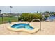 Relax in this kidney bean shaped hot tub surrounded by colorful flowers and lounge chairs on a brick patio at 149 Englewood Isles Pkwy # 603, Englewood, FL 34223