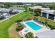 Overhead view of community pool with surrounding lounge chairs, landscaping, and docks on the water at 149 Englewood Isles Pkwy # 603, Englewood, FL 34223