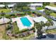 Aerial view of the community pool, surrounded by lounge chairs and mature landscaping at 149 Englewood Isles Pkwy # 603, Englewood, FL 34223
