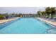 Community in-ground pool with lounge chairs and well-maintained landscaping at 149 Englewood Isles Pkwy # 603, Englewood, FL 34223