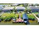 An aerial view of a waterfront home with a private boat dock and a screened-in pool area at 15176 Spanish Point Dr, Port Charlotte, FL 33981