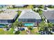 Aerial view showcases gray roof, palm trees, beautiful landscaping, screened in lanai, and a private pool at 15176 Spanish Point Dr, Port Charlotte, FL 33981