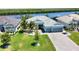Attractive aerial view of a single-story home with a three-car garage, manicured lawn, and a serene waterfront backdrop at 15176 Spanish Point Dr, Port Charlotte, FL 33981