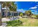 Expansive backyard featuring lush lawn, swaying palms, and a private dock, creates a serene retreat for outdoor living at 15176 Spanish Point Dr, Port Charlotte, FL 33981
