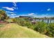 Waterfront dock featuring a boat lift and covered seating, surrounded by lush landscaping and serene water views at 15176 Spanish Point Dr, Port Charlotte, FL 33981
