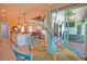 Inviting dining area adjacent to the kitchen, featuring blue chairs, light wood table, and a vase of flowers at 15176 Spanish Point Dr, Port Charlotte, FL 33981
