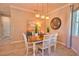 Dining room with a wooden table, white chairs, decorative pendants and a large decorative clock at 15176 Spanish Point Dr, Port Charlotte, FL 33981