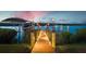 A private dock is illuminated at dusk, providing access to serene waterfront views and boat mooring at 15176 Spanish Point Dr, Port Charlotte, FL 33981