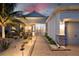 Charming single-story home with manicured landscaping, stone accents, and a brick walkway illuminated at twilight at 15176 Spanish Point Dr, Port Charlotte, FL 33981
