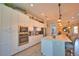 Spacious white kitchen with stainless appliances and center island breakfast bar at 15176 Spanish Point Dr, Port Charlotte, FL 33981