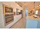 Modern kitchen with stainless steel appliances, white cabinets, and mosaic backsplash at 15176 Spanish Point Dr, Port Charlotte, FL 33981