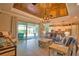 Spacious living room featuring a wood-plank ceiling, tile floors, slider to the lanai, and open to the kitchen at 15176 Spanish Point Dr, Port Charlotte, FL 33981