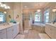 Stylish main bathroom featuring double vanity sinks, soaking tub, and a walk-in shower with decorative lighting at 15176 Spanish Point Dr, Port Charlotte, FL 33981