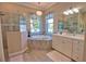 Elegant bathroom boasts a soaking tub, separate shower, double sinks, decorative light fixtures, and tile flooring at 15176 Spanish Point Dr, Port Charlotte, FL 33981