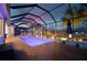 A dazzling pool and patio area is illuminated at twilight, creating a serene and inviting outdoor oasis for relaxation and enjoyment at 15176 Spanish Point Dr, Port Charlotte, FL 33981