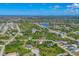 Expansive aerial view of a residential community featuring a serene lake, lush greenery, and charming homes at 161 Haddock Dr, Rotonda West, FL 33947