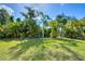 View of the backyard, showcasing the tropical landscaping surrounding the property at 161 Haddock Dr, Rotonda West, FL 33947