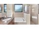 Bright bathroom with a soaking tub, a glass-enclosed shower, and large window at 161 Haddock Dr, Rotonda West, FL 33947