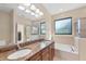 Bright bathroom featuring a double vanity, soaking tub, and a separate glass-enclosed shower at 161 Haddock Dr, Rotonda West, FL 33947