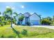 Well maintained home with landscaped front yard, brick driveway, and mature palm trees at 161 Haddock Dr, Rotonda West, FL 33947