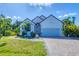 Charming single-Gathering home with a well-manicured lawn, brick driveway, and tropical landscaping at 161 Haddock Dr, Rotonda West, FL 33947
