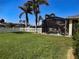 Spacious backyard featuring a screened-in pool, lush lawn, and a charming white picket fence under a clear sky at 174 Broadmoor Ln, Rotonda West, FL 33947