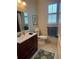 Well-lit bathroom featuring a wood-look tile floor, updated vanity, and natural light at 174 Broadmoor Ln, Rotonda West, FL 33947
