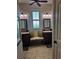 Bright bathroom with wood tile floors, dual sink vanities, decor pillows and a window between the mirrors at 174 Broadmoor Ln, Rotonda West, FL 33947