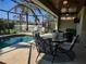 Screened-in lanai featuring a dining area with pool views, ideal for relaxing and entertaining at 174 Broadmoor Ln, Rotonda West, FL 33947