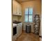 Well-lit laundry room with updated appliances, storage, and window at 174 Broadmoor Ln, Rotonda West, FL 33947