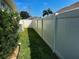 Side yard showcasing a well-maintained vinyl fence and lush green grass between neighboring homes at 174 Broadmoor Ln, Rotonda West, FL 33947
