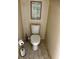 Small water closet featuring white toilet, wood-look tile floors and a decorative print on the wall at 174 Broadmoor Ln, Rotonda West, FL 33947