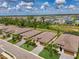 A high angle aerial shot showcases neighborhood homes, manicured landscaping, and a scenic pond under a partly cloudy sky at 1836 W Isles Rd, Port Charlotte, FL 33953