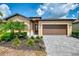 An inviting home exterior is enhanced by verdant landscaping, a paved driveway, and a matching garage door at 1836 W Isles Rd, Port Charlotte, FL 33953