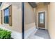 Close up of the front entryway featuring a brown door with a glass panel and sidelight at 1836 W Isles Rd, Port Charlotte, FL 33953
